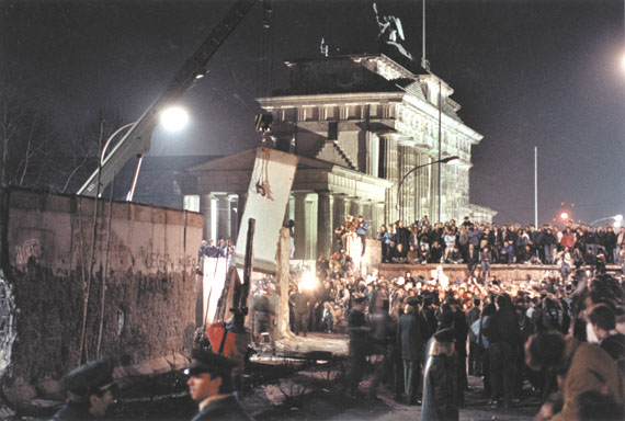 A section of the Berlin Wall is lifted by a crane as workers start to dismantle the structure near the Brandenburg Gate, East Berlin, December 22, 1989.